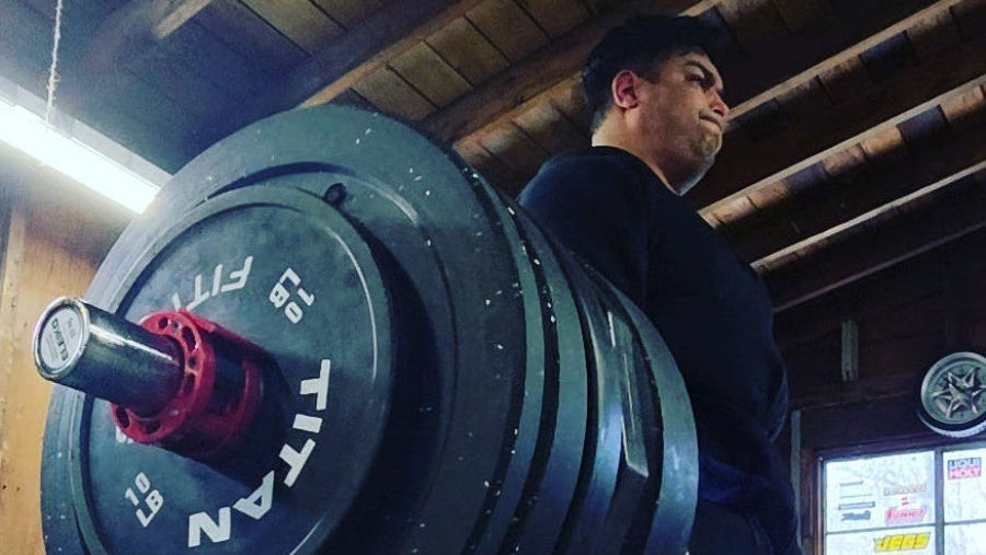 Person lifting a heavily loaded barbell in a gym setting